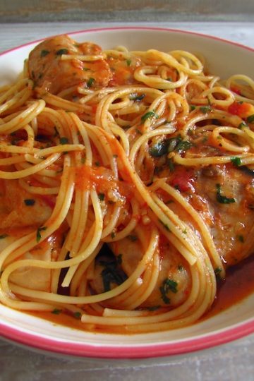 Stewed rabbit with spaghetti on a plate with a fork