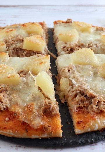 Homemade cheese pizza with tuna and pineapple Recipe on a table
